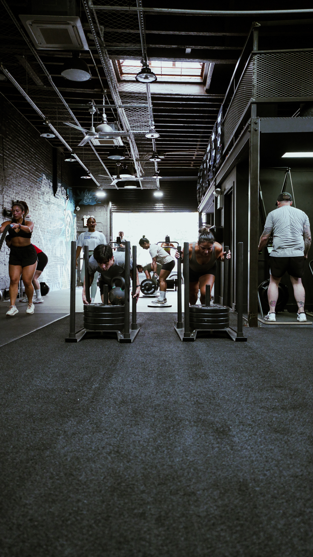 Athlete pushing a sled on the turf at BOLT Fitness